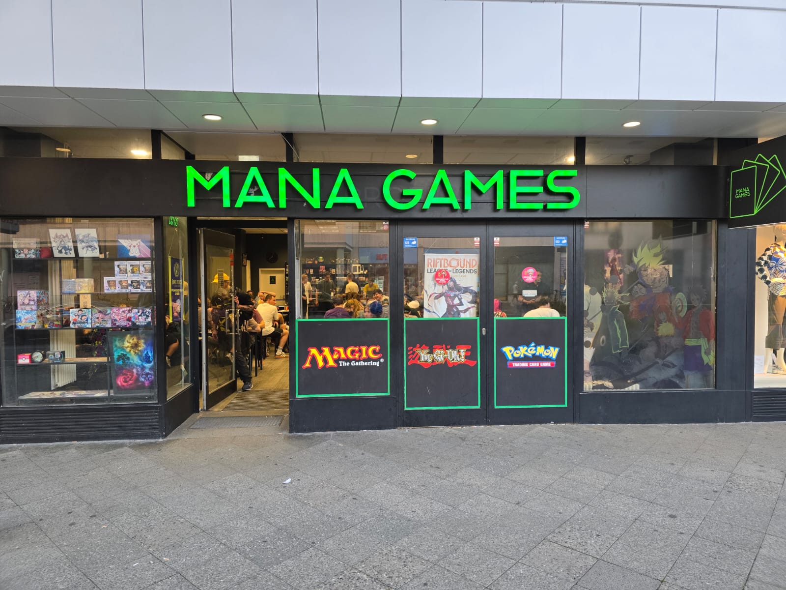 The Mana Games storefront on Blissestrasse in Berlin at dusk